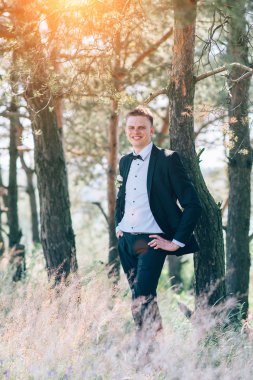 Gülümseyen ve gelin için bekleyen düğün smokin, yakışıklı damat.