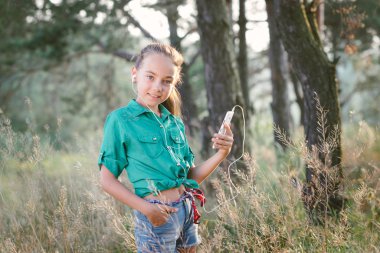 Küçük şirin kız açık havada ormanda boş zamanını harcıyor.