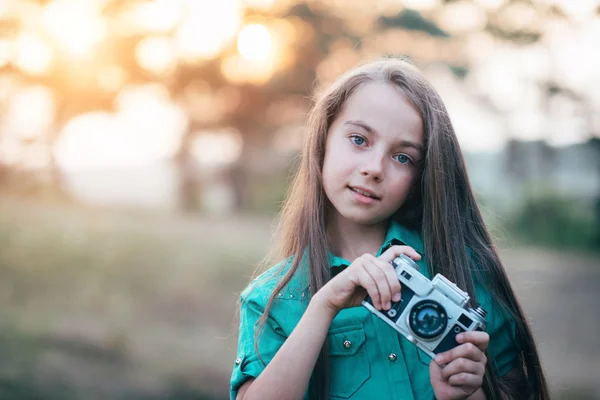 Portrait d'une jolie petite fille brune souriante et tenant un — Photo