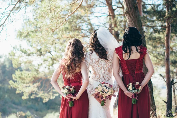Esküvői virágok a kezében, a menyasszony és a koszorúslány. A lakoma-f — Stock Fotó