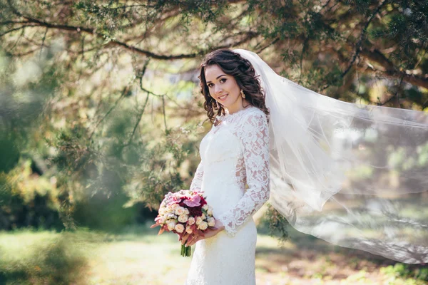 Beautiful bride outdoors in a forest. — Stock Photo, Image