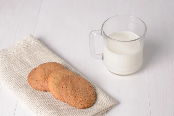 Homemade ginger cookies with a glass of milk on a wooden light b — Stock Photo, Image