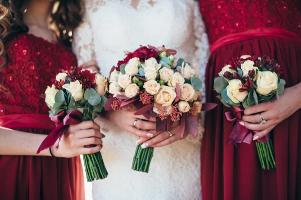 Flores de casamento na mão a noiva e as suas damas de honra. Um banquete f — Fotografia de Stock