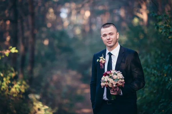 Pohledný ženicha na svatební oblek usmívá a čekání na nevěstu. — Stock fotografie