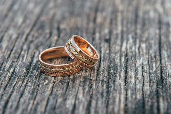 Anéis de casamento em mãos de noiva no fundo de madeira — Fotografia de Stock