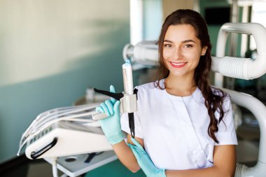 İş yerinde beyaz önlüklü genç bayan dişçi.
