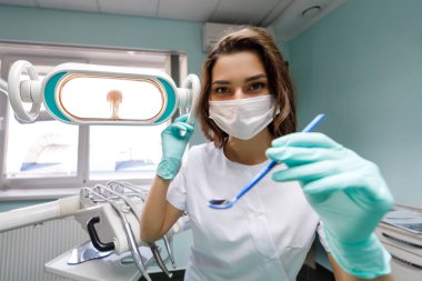 İş yerinde beyaz önlüklü genç bayan dişçi.