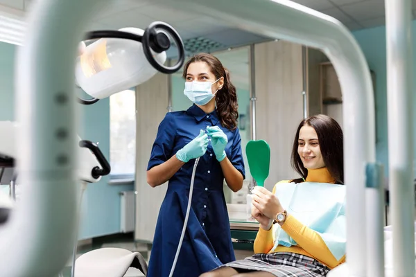 Jonge Vrouw Zit Tandartsstoel Tandarts Onderzoekt Zorgvuldig Tanden Van Patiënt — Stockfoto