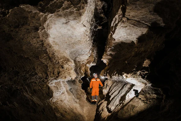 洞窟の深い垂直トンネルのロープで洞窟学者が降下します — ストック写真