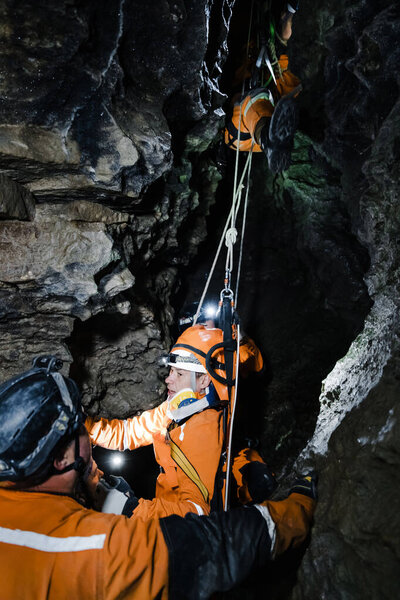 Cave rescuer helping injured climber