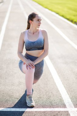 Sıska genç kız antrenmandan önce ısınıyor.