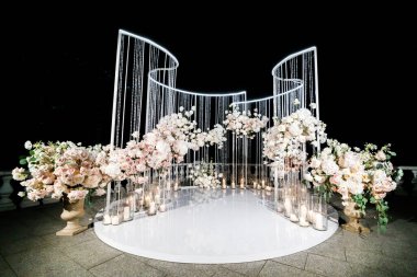 Yeni evlilerin düğünü için düğün kemeri. Düğün kutlaması gece dışarıda.