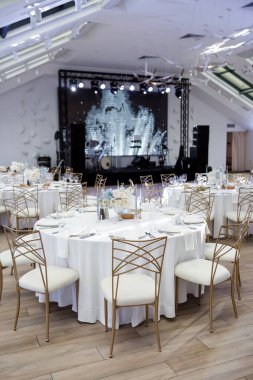 Çiçeklerle, peçetelerle, çatal bıçaklarla, gözlüklerle, parlak yaz masa dekorlarıyla süslü bir düğün masası..