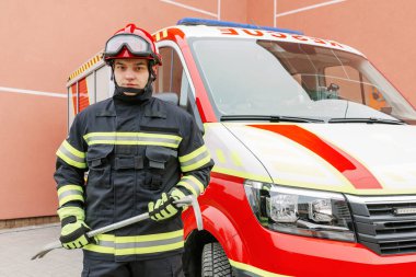 Üniformalı ve kasklı güçlü bir adam kurtarma aracının yanında duruyor. Kurtarıcı.