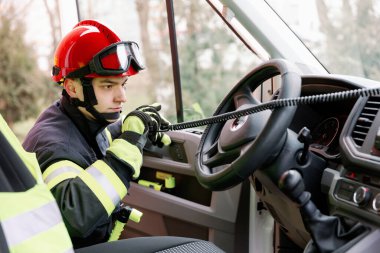 Üniformalı ve kasklı güçlü bir adam kurtarma aracının yanında duruyor. Kurtarıcı.
