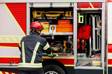 Üniformalı ve kasklı güçlü bir adam kurtarma aracının yanında duruyor. Kurtarıcı.