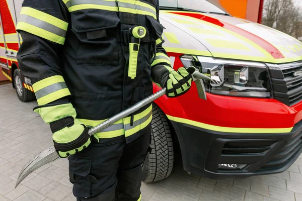 制服姿でヘルメット姿の強い男が救助車のそばに立っていた 救助者だ — ストック写真