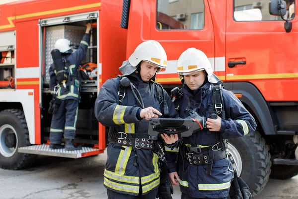 消防における消防士2人 防護服の消防士 戦闘中のタブレットコンピュータを使用したヘルメットの肖像 — ストック写真