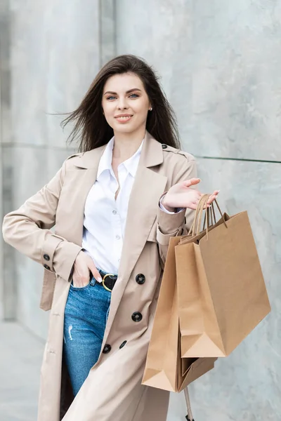 ショッピングバッグやショッピングセンターの近くの購入の多くを持つカジュアルな服の女の子は彼女のパッケージ 消費者販売 人々のコンセプトを笑顔で手 — ストック写真
