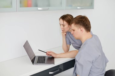 Bir grup neşeli sağlık çalışanı doktorun ofisinde birlikte çalışıyor. Hastalar için tedavi hakkında bilgi bulunması.