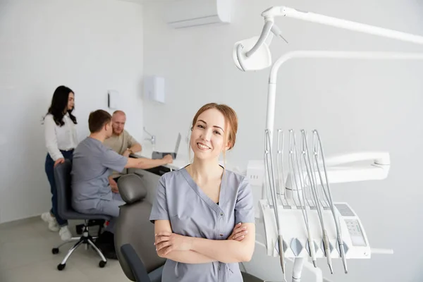 Ung Söt Kvinnlig Tandläkare Står Mitt Kontoret Och Bakgrunden Kollega — Stockfoto