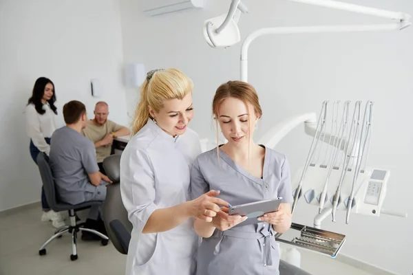 Young Pretty Woman Dentist Her Assistant Standing Middle Office Tablet — Stock Photo, Image