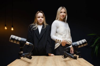 Kadın podcaster profesyonel bir stüdyoda dans ediyor ve gülüyor, ilgi çekici ses içeriği yaratıyor.