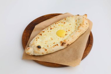 Geleneksel Gürcü pastası. Peynirli ve çiğ yumurtalı Adjarian Khachapuri. Khachapuri ahşap tahtada yumurta ile beyaz arka planda kırsal tarzda.