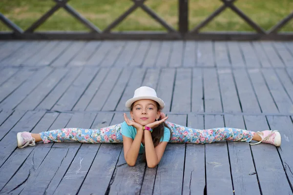 Beautiful stylish young woman sitting on the splits on the backg — Stock Photo, Image