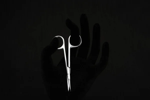                     tırnak makası elinde siyah arkaplanda                      