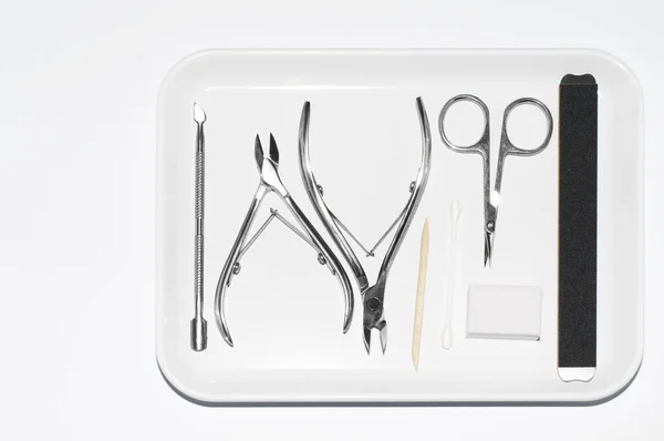 Manikür makası, makas, spatula, gri arka planda tırnak bakımı için.