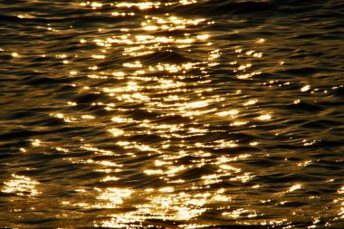 Batan güneşin parlaklığı Baltık Denizi 'nin sakin dalgalarına yansıdı.