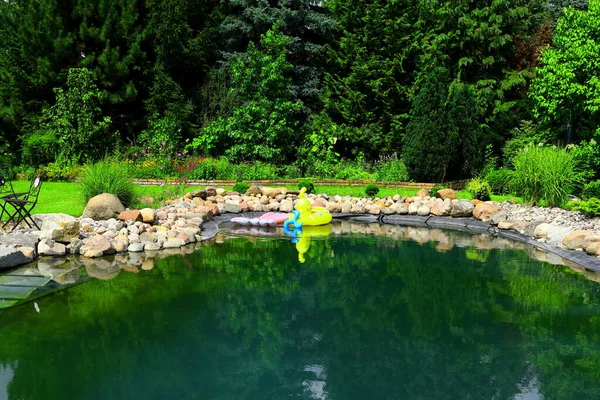 Bahçedeki doğal taşlardan yapılmış yüzme havuzu.