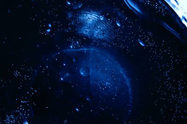 Renkli bir arka planda, sudaki yağ kabarcıkları makro fotoğraf konsepti olarak gösterilir.