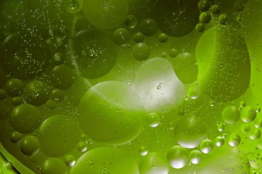 Renkli bir arka planda, sudaki yağ kabarcıkları makro fotoğraf konsepti olarak gösterilir.
