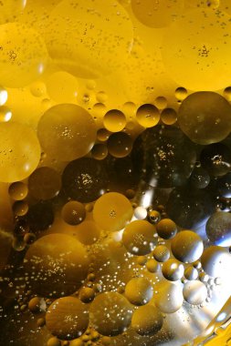 Renkli bir arka planda, sudaki yağ kabarcıkları makro fotoğraf konsepti olarak gösterilir.