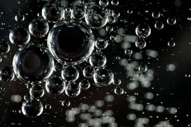 Renkli bir arka planda, sudaki yağ kabarcıkları makro fotoğraf konsepti olarak gösterilir.