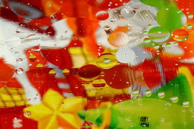 Renkli bir arka planda, sudaki yağ kabarcıkları makro fotoğraf konsepti olarak gösterilir.