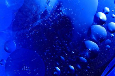 Renkli bir arka plana karşı su makrosu içinde yağ kabarcıkları