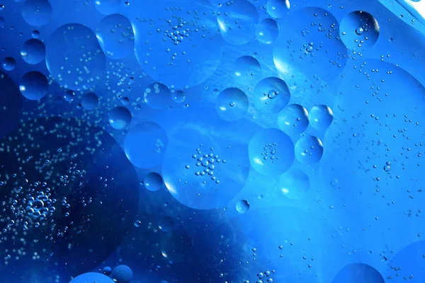 Renkli bir arka plana karşı su makrosu içinde yağ kabarcıkları