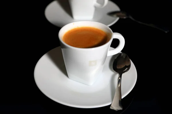 黒の背景にエスプレッソコーヒーの白いカップ — ストック写真