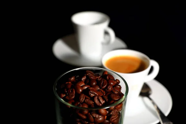 Kaffeebohnen Und Eine Weiße Tasse Espresso Auf Schwarzem Hintergrund — Stockfoto