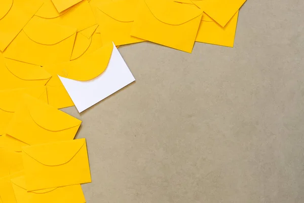 Sarı zarflar gri bir taş masaya saçılmış, yazı için boşluk, ve üst görünüm
