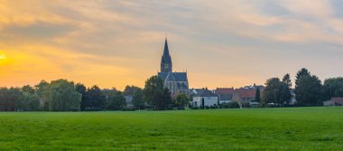 St. Michael Abbey Kilisesi 'nin hakim kulesiyle gün batımında Limburg eyaletinin Thorn kasabasının panoraması