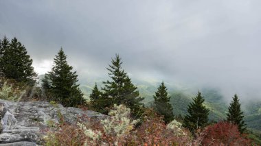 Fog giving way to the sun over the Blue Ridge Mountains of the Appalachian Highlands range at the top of Devil's Courthouse off of the Blue Ridge Parkway in North Carolina.