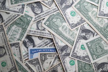 Sosyal güvenlik kartı birkaç tane 1 dolarlık banknotla çevrili.