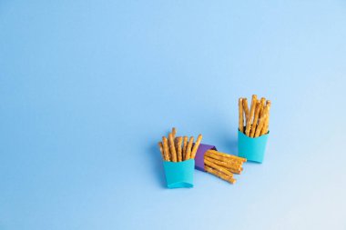 Mavi arka planı olan mavi çubuk kraker kutuları. Parti atıştırmalıkları. Ulusal Simit Günü.