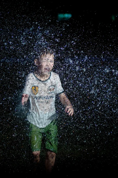 Boy in the rain in the evening — Stock Photo, Image