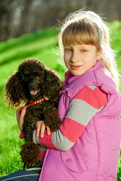 Chica con el caniche negro en la naturaleza — Foto de Stock