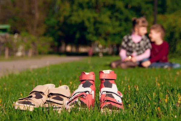 Sandalen op een achtergrond van de jongen met het meisje — Stockfoto